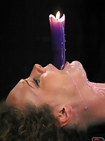 Bound submissive holds a lit candle in her mouth