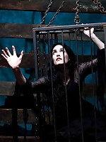 Goth girl in cage and stocks